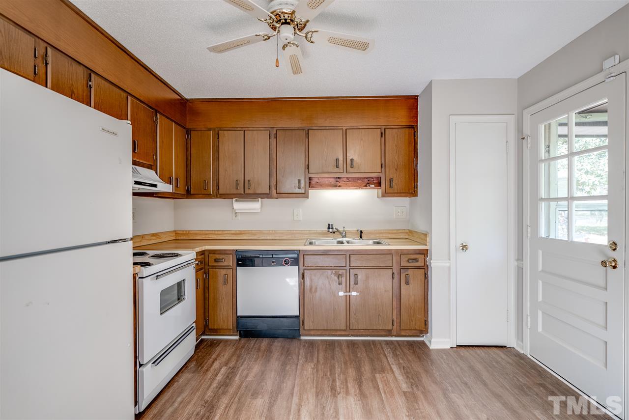 7408 Mine Shaft Road Raleigh, NC 27615 - Photo 16 of 20 a kitchen with stainless steel appliances granite countertop a stove a sink and a refrigerator with wooden floors