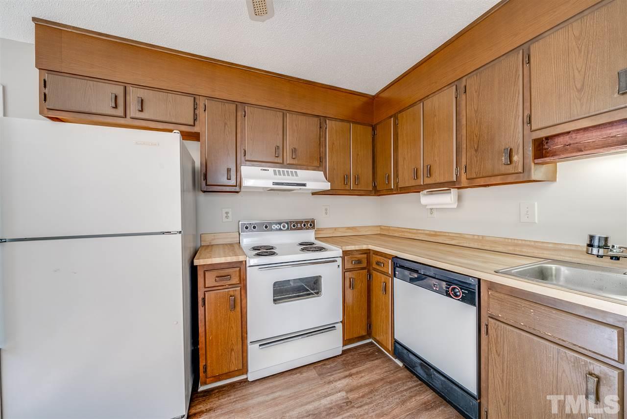 7408 Mine Shaft Road Raleigh, NC 27615 - Photo 17 of 20 a kitchen with a sink a refrigerator and cabinets