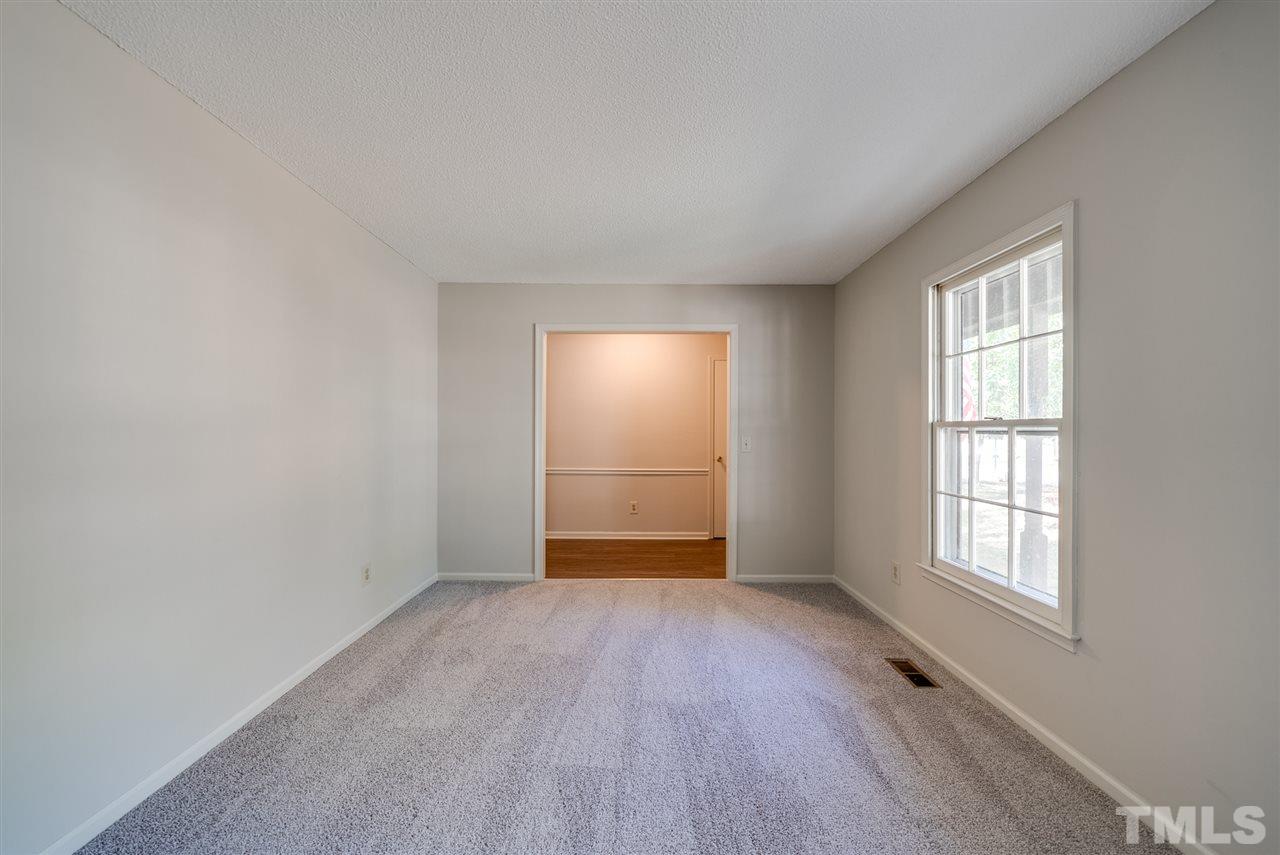 7408 Mine Shaft Road Raleigh, NC 27615 - Photo 4 of 20 an empty room with wooden floor and windows