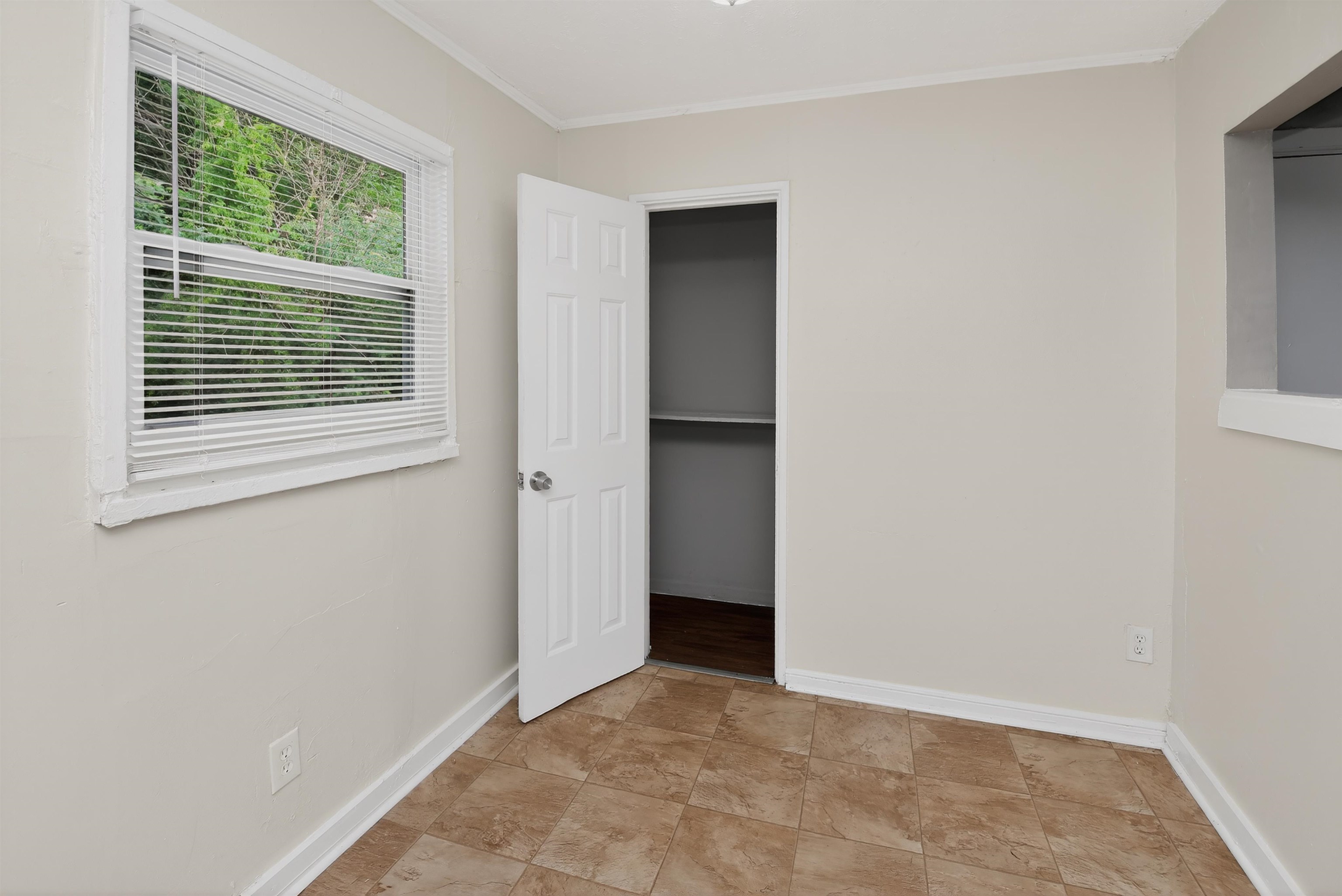 4838 Manson Road Memphis, TN 38109 - Photo 22 of 28 Neutral-toned walls and durable tile flooring define this room, featuring a window with white blinds