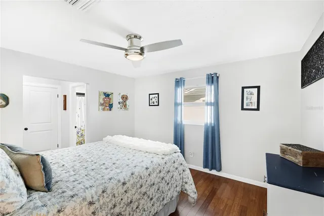 a bedroom with a bed and wooden floor