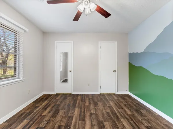 a view of a livingroom with wooden floor and a ceiling fan