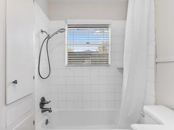 a bathroom with a bath tub with a shower