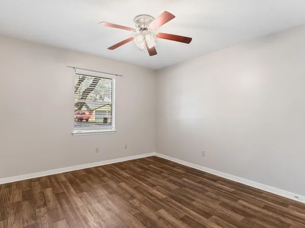 an empty room with a window and a ceiling fan
