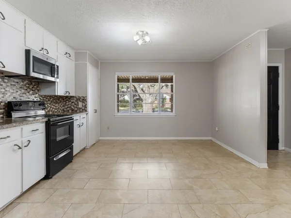 a kitchen with a stove a sink and a microwave