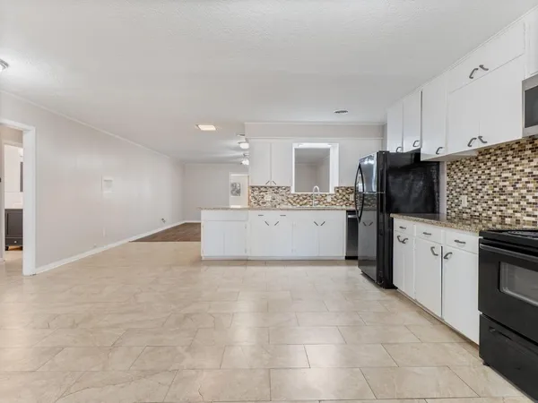 a kitchen with granite countertop a sink stainless steel appliances and cabinets