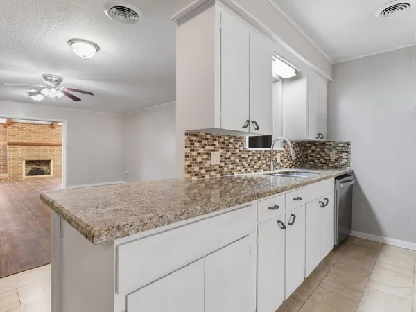 a bathroom with a granite countertop sink and white cabinets
