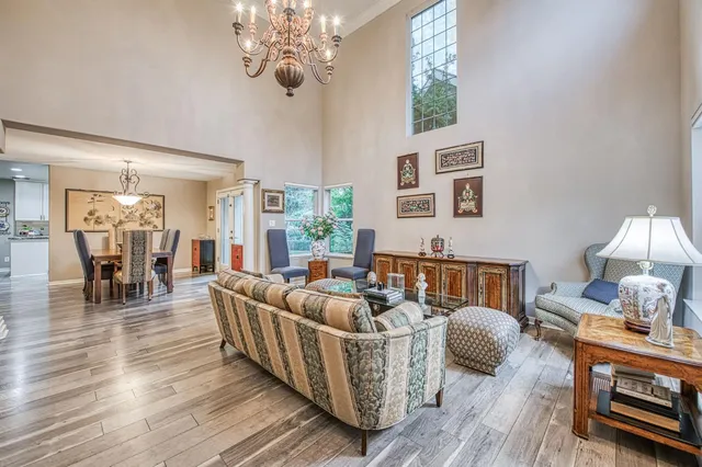 a living room with furniture a chandelier and a table