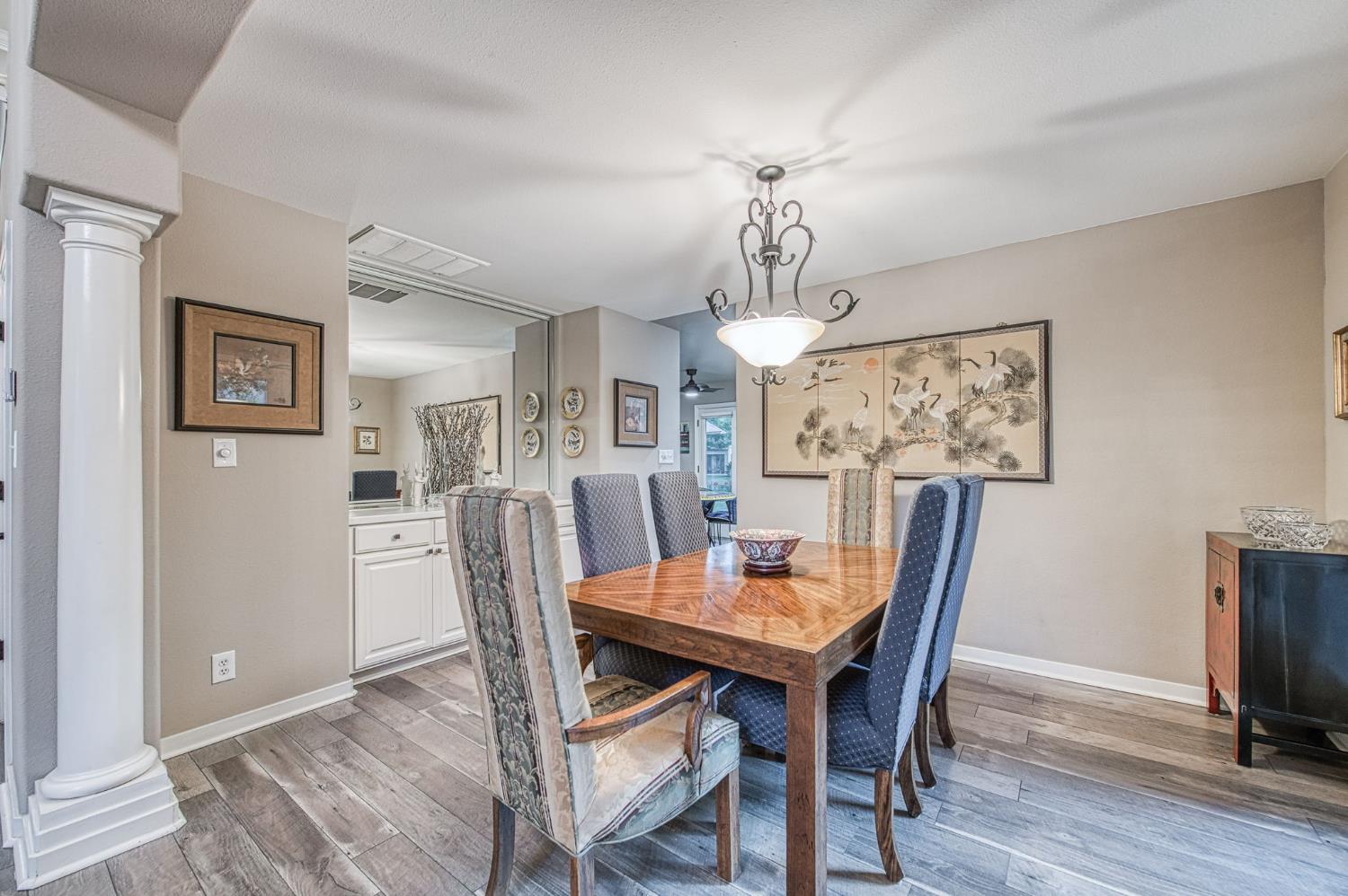 3077 West Pembrook Loop Fresno, CA 93711 - Photo 22 of 56 a view of a dining room with furniture a chandelier and wooden floor