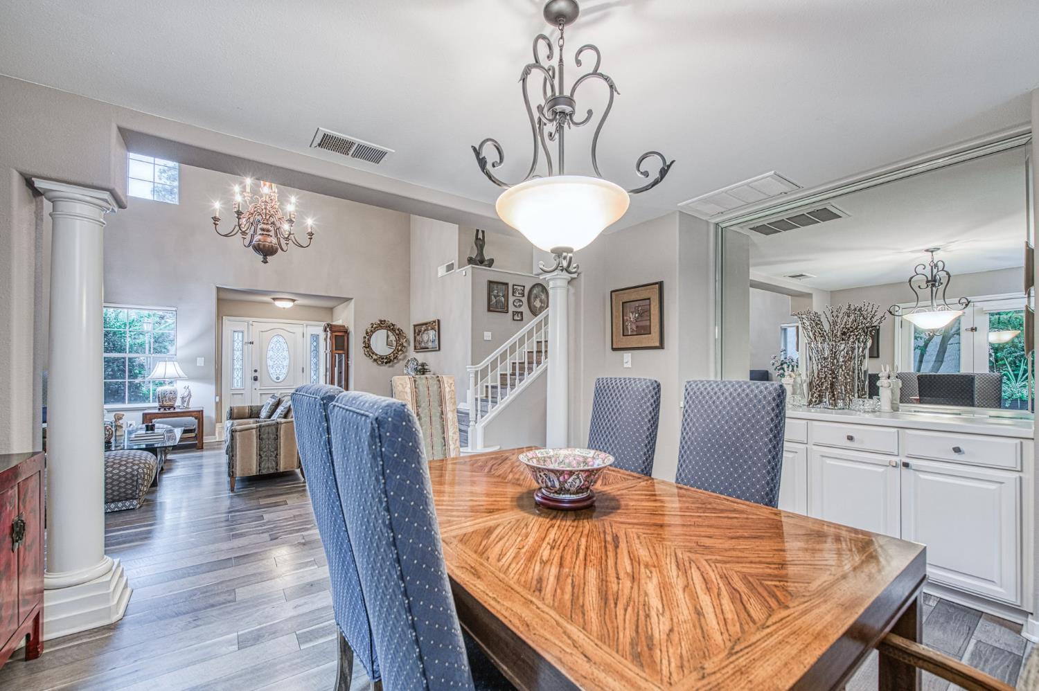 3077 West Pembrook Loop Fresno, CA 93711 - Photo 23 of 56 a view of a dining room with furniture a chandelier and wooden floor