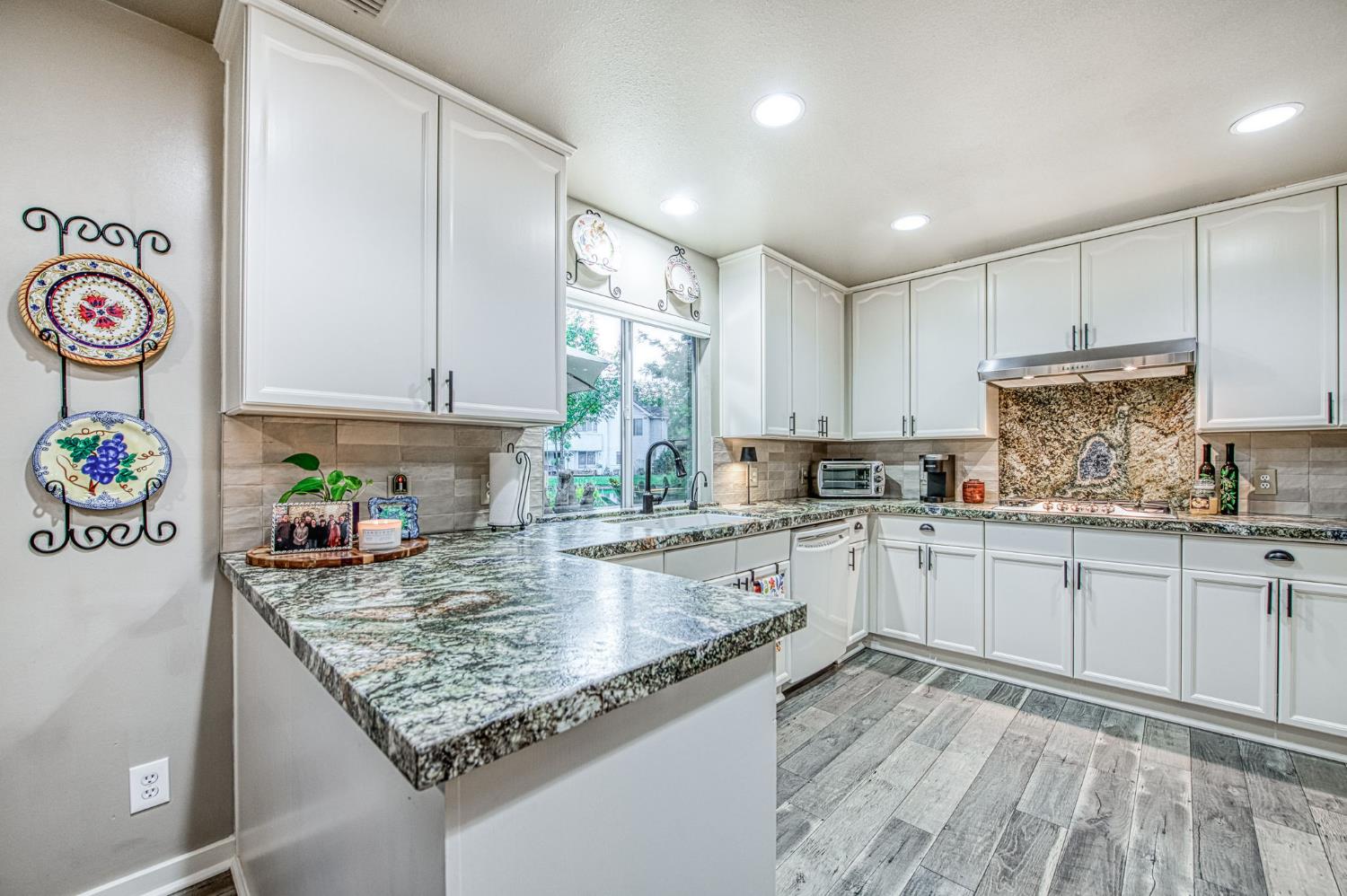 3077 West Pembrook Loop Fresno, CA 93711 - Photo 32 of 56 a kitchen with granite countertop a sink a stove and cabinets