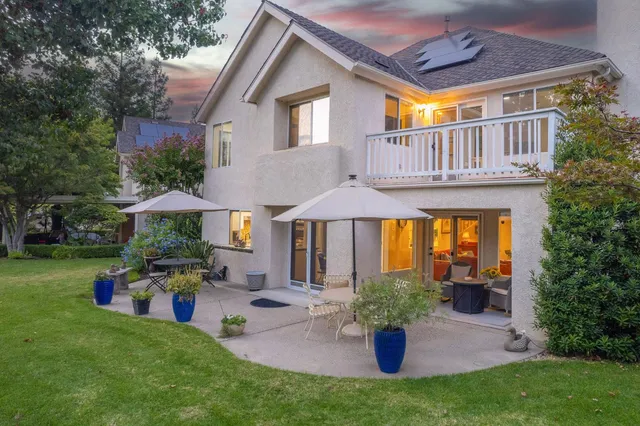 a front view of a house with a yard garden and outdoor seating