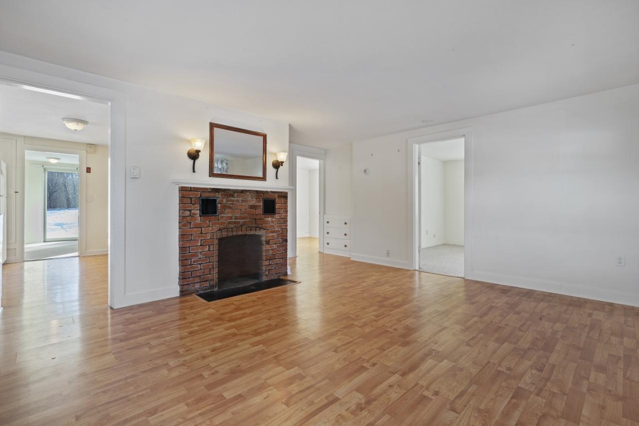 59 Fire Station Road Osterville, MA 02655 - Photo 6 of 31 an empty room with wooden floor and fireplace