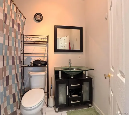 a bathroom with a toilet a sink and a shower curtain