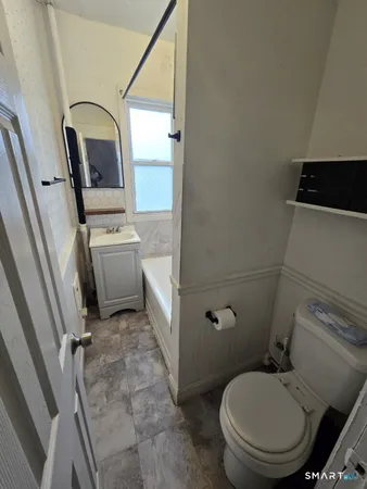 a bathroom with a toilet sink and mirror