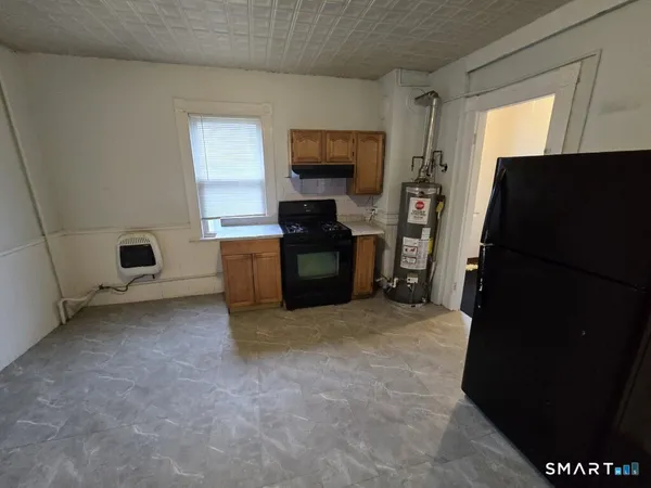 a living room with stainless steel appliances furniture a fireplace and a flat screen tv