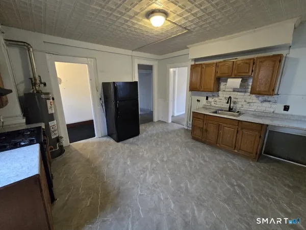 a large kitchen with a stove a refrigerator and a sink