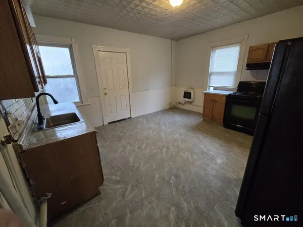 a view of workspace with kitchen flooring and a refrigerator