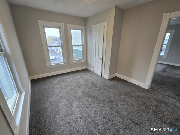 an empty room with windows and closet