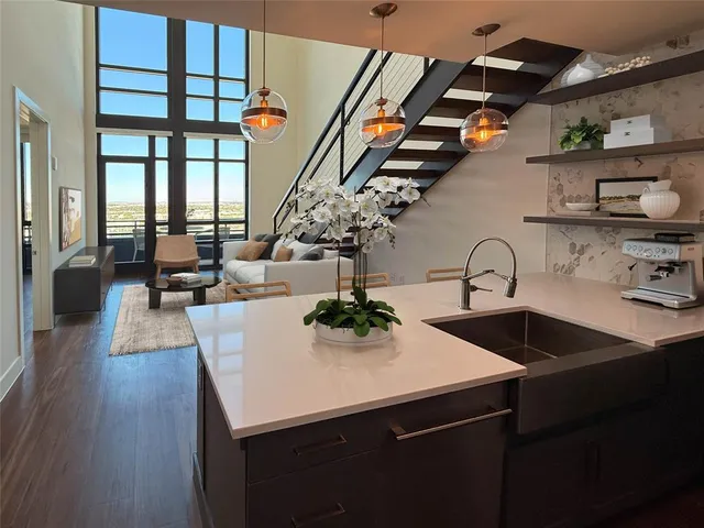 a kitchen with a sink a refrigerator and wooden floor