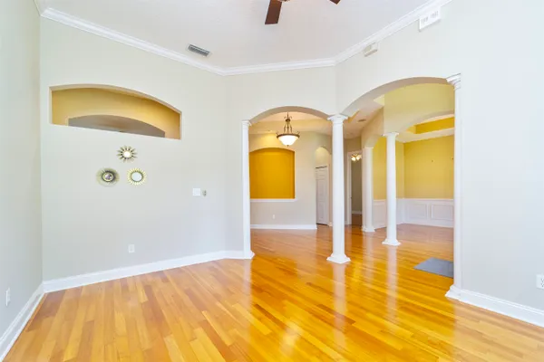 a view of a livingroom with a fireplace a ceiling fan and wooden floor