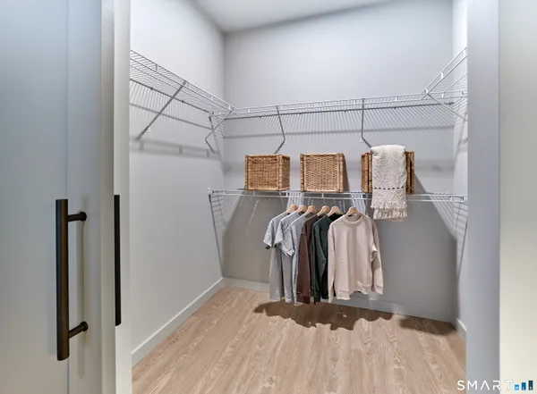 a view of walk in closet with clothes and shoes