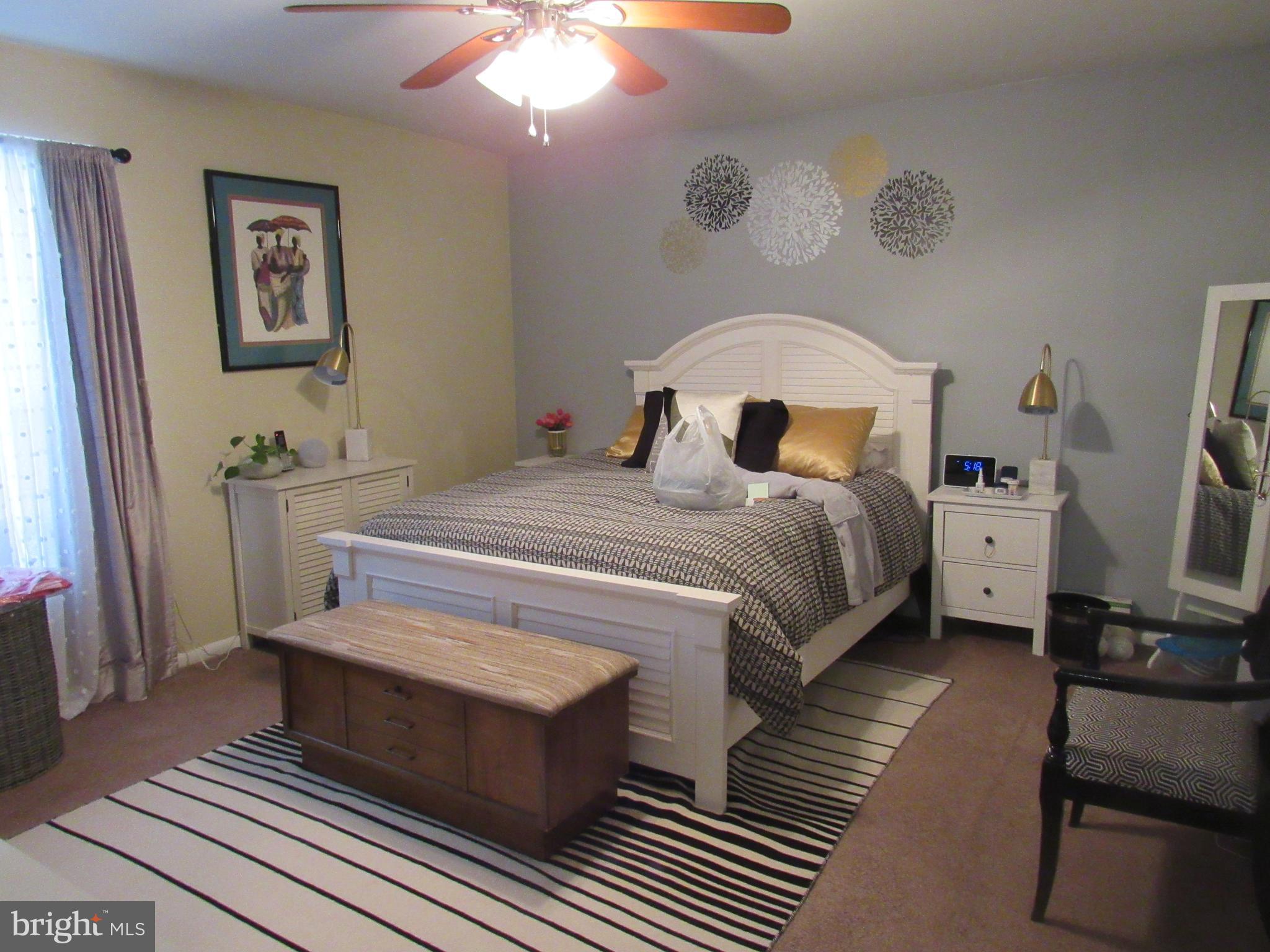 4000 Gypsy Lane, Unit 622F1 Philadelphia, PA 19129 - Photo 24 of 45 a bedroom with a bed and a flat tv screen on dresser