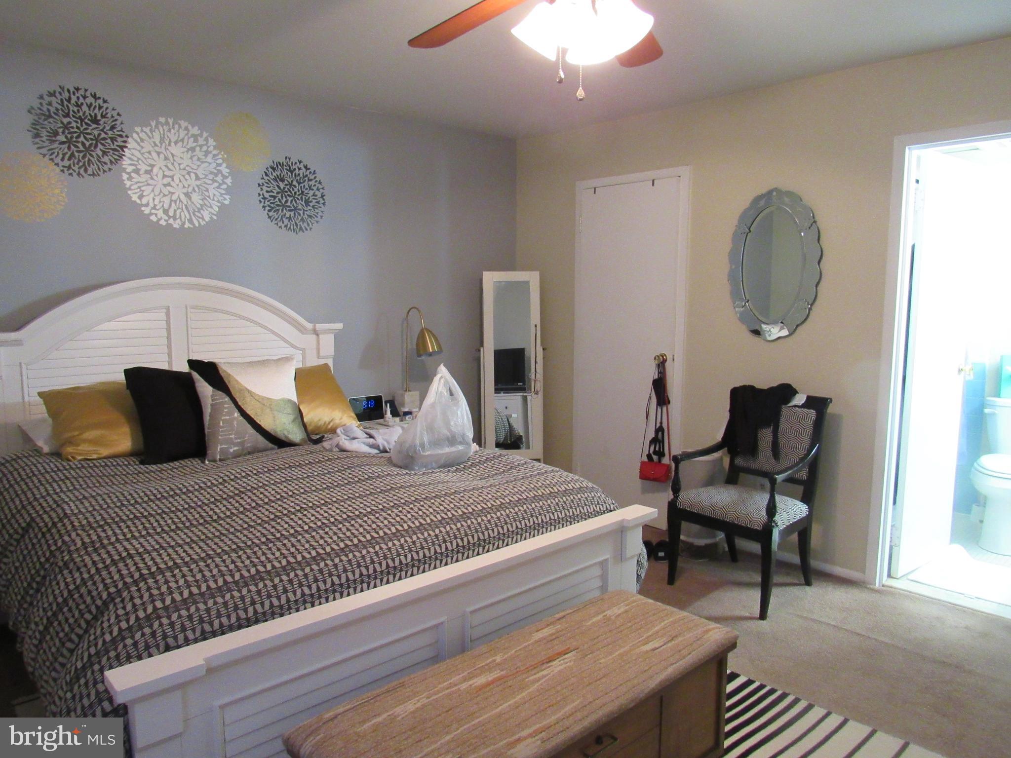 4000 Gypsy Lane, Unit 622F1 Philadelphia, PA 19129 - Photo 27 of 45 a bedroom with a bed and a chandelier