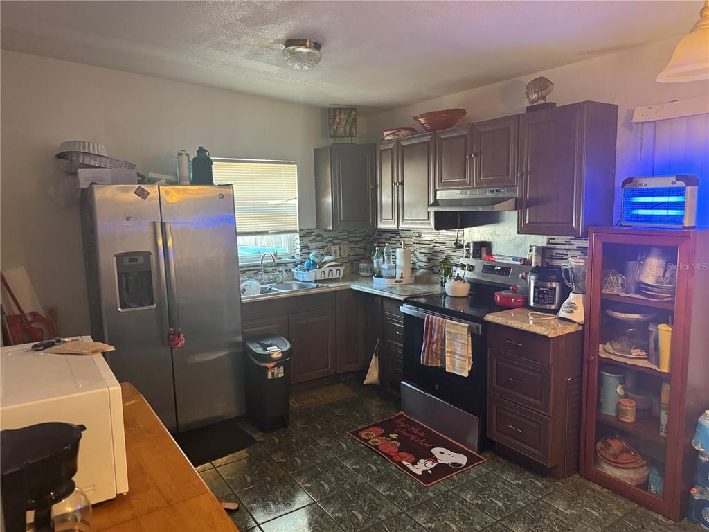 1620 36th Street Orlando, FL 32839 - Photo 5 of 7 a kitchen with stainless steel appliances granite countertop a refrigerator a stove a sink and dishwasher