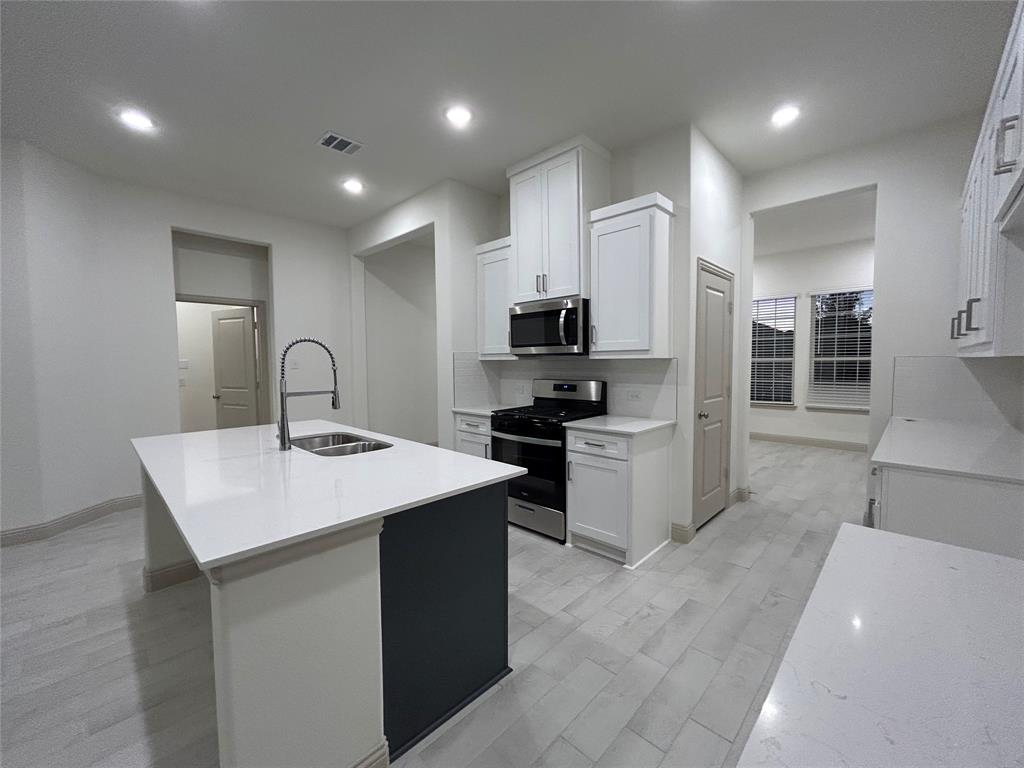 2905 Italia Terrace Princeton, TX 75407 - Photo 11 of 22 a kitchen with sink a microwave and cabinets