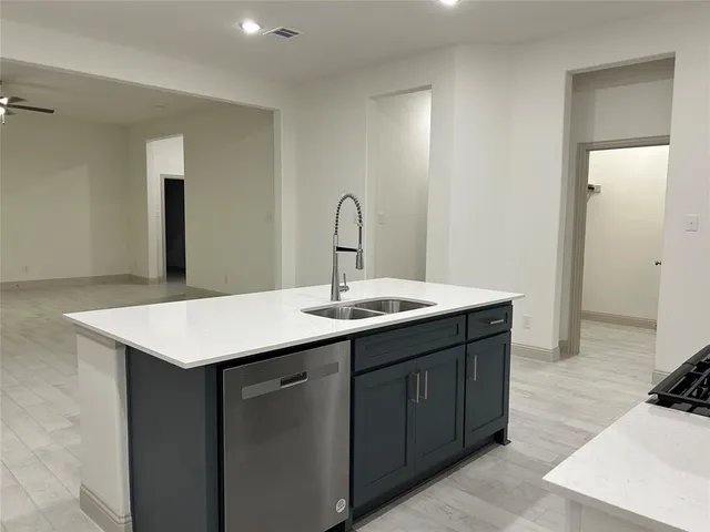 a open kitchen with white cabinets and stainless steel appliances