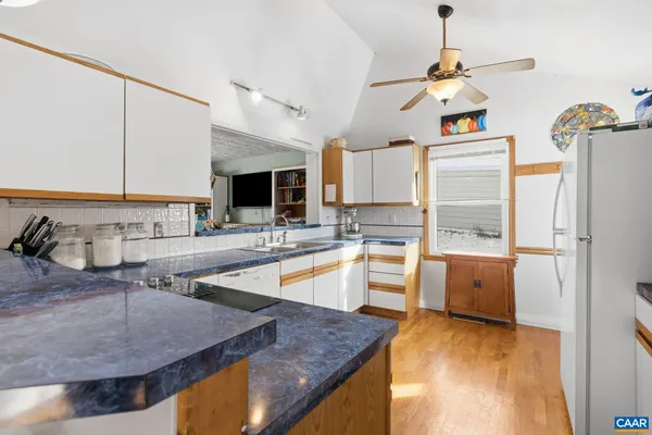 a kitchen with stainless steel appliances granite countertop a sink and a refrigerator