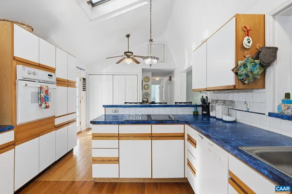 a kitchen with stainless steel appliances granite countertop a sink a stove and a wooden floors