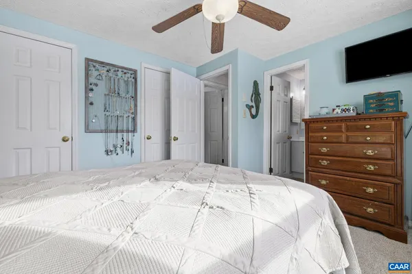 a bedroom with a bed a flat screen tv and a dresser