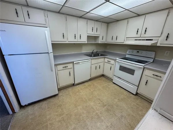 a kitchen with cabinets and white appliances
