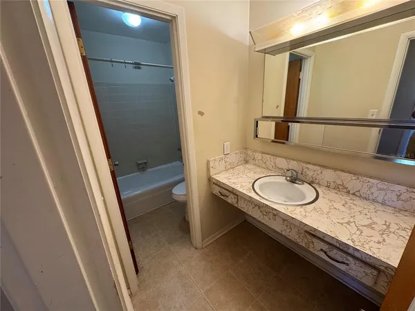 a bathroom with a granite countertop sink and a mirror