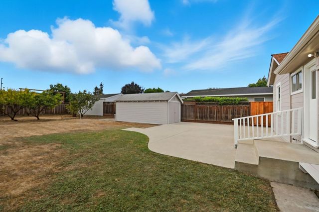a view of a house with a yard and potted plants