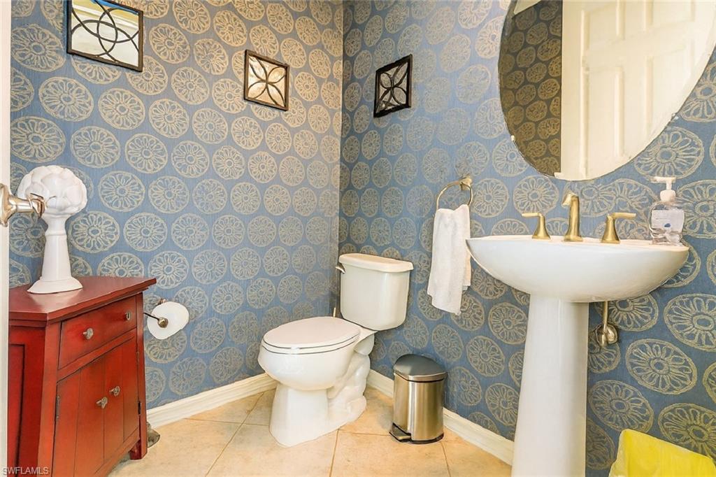 9055 Capistrano Street North, Unit 4206 Naples, FL 34113 - Photo 12 of 45 a bathroom with a toilet sink and mirror