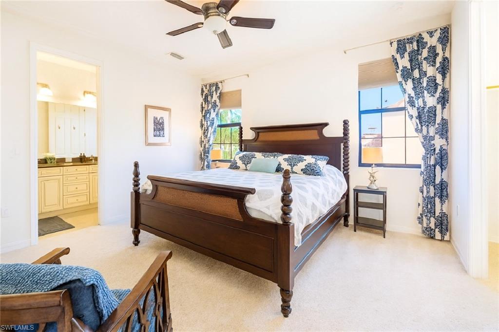 9055 Capistrano Street North, Unit 4206 Naples, FL 34113 - Photo 16 of 45 a bedroom with a bed and a table in it