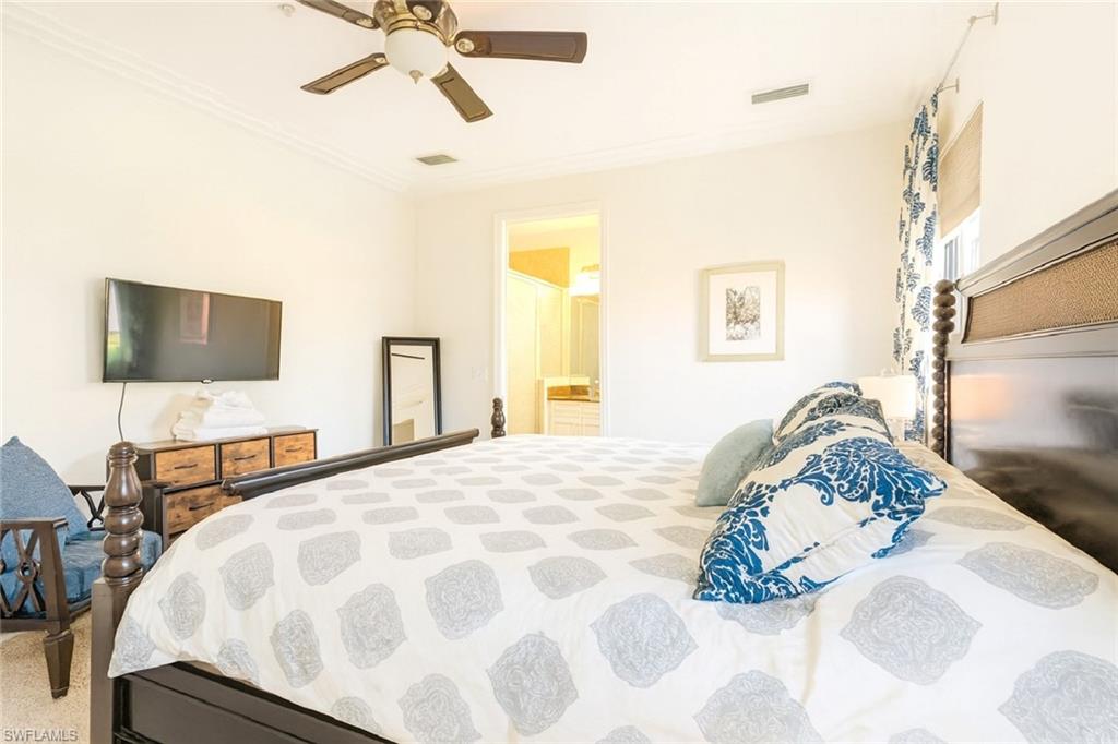 9055 Capistrano Street North, Unit 4206 Naples, FL 34113 - Photo 17 of 45 a bedroom with a bed and a flat tv screen on dresser