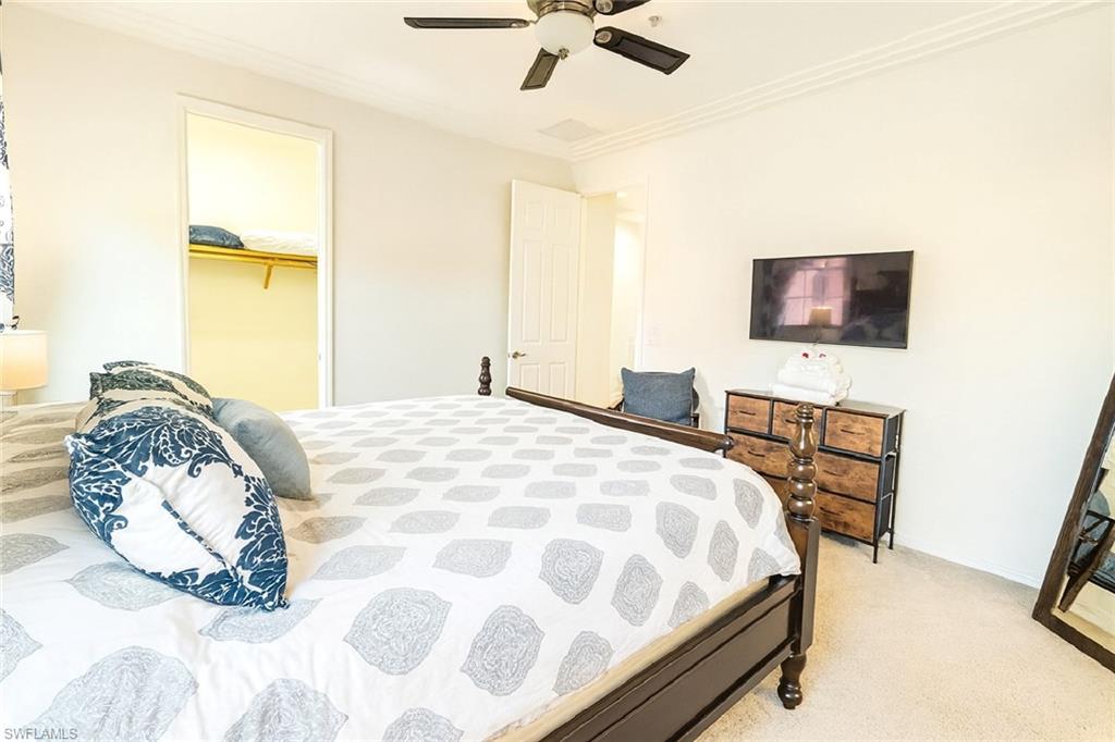 9055 Capistrano Street North, Unit 4206 Naples, FL 34113 - Photo 18 of 45 a bedroom with a bed and a flat screen tv