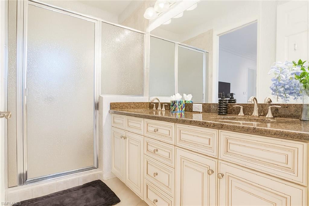 9055 Capistrano Street North, Unit 4206 Naples, FL 34113 - Photo 20 of 45 a bathroom with a granite countertop sink and a mirror