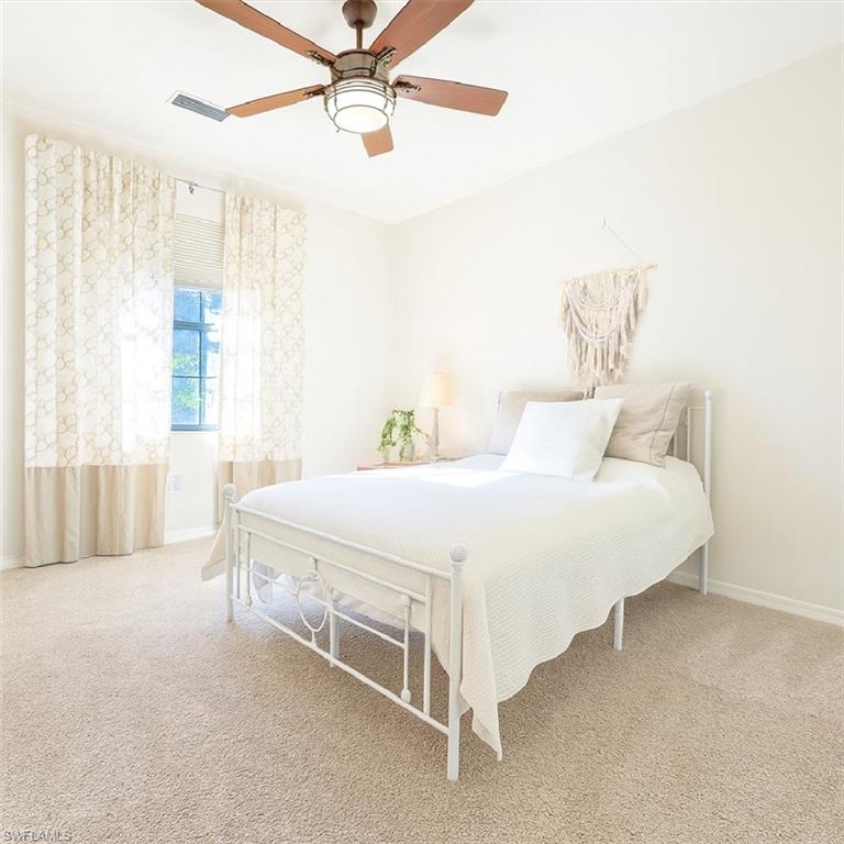 9055 Capistrano Street North, Unit 4206 Naples, FL 34113 - Photo 21 of 45 a spacious bedroom with a bed and a chandelier