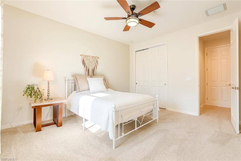 9055 Capistrano Street North, Unit 4206 Naples, FL 34113 - Photo 22 of 45 a bedroom with a bed and a chandelier