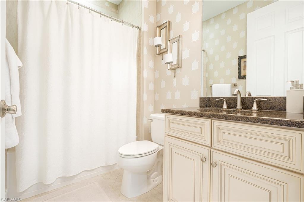 9055 Capistrano Street North, Unit 4206 Naples, FL 34113 - Photo 23 of 45 a bathroom with a granite countertop sink and a mirror