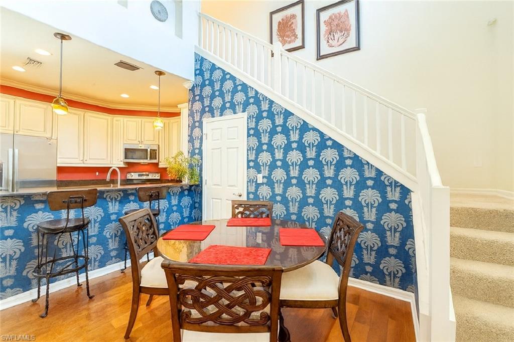 9055 Capistrano Street North, Unit 4206 Naples, FL 34113 - Photo 5 of 45 a dining room with furniture and wooden floor