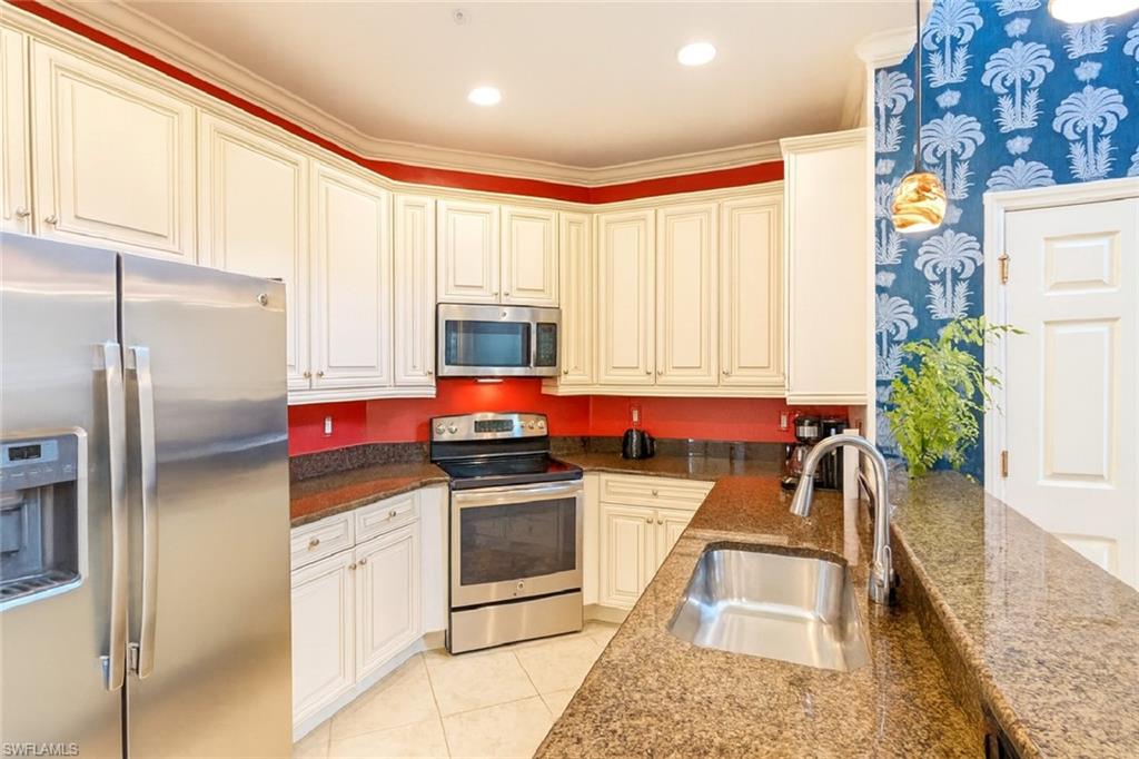 9055 Capistrano Street North, Unit 4206 Naples, FL 34113 - Photo 9 of 45 a kitchen with stainless steel appliances granite countertop a refrigerator sink and stove