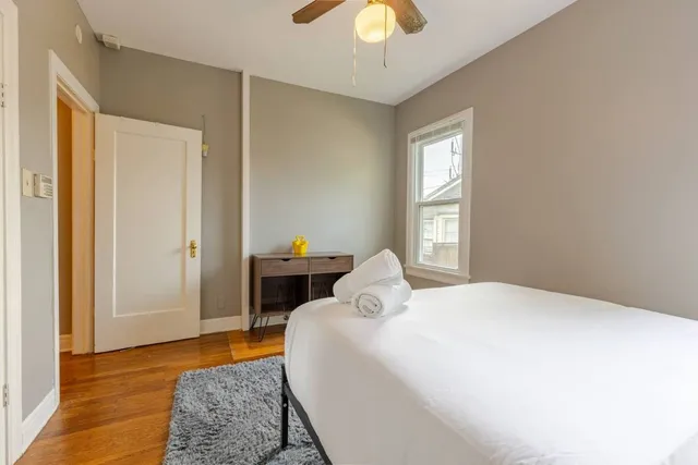 a bedroom with a bed rug and wooden floor