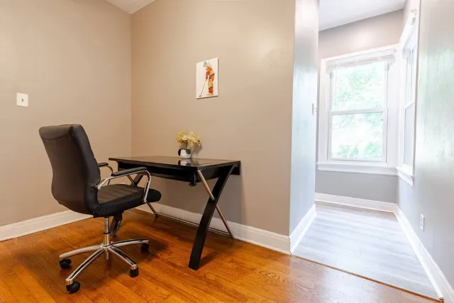 a view of a workspace with furniture and a window