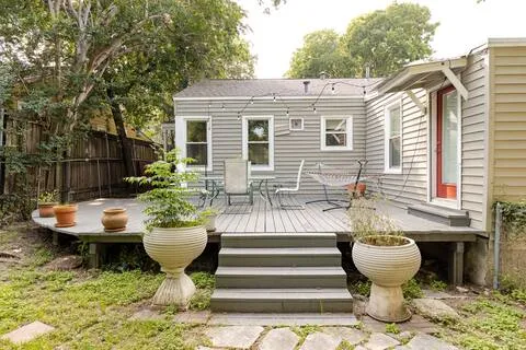 a view of a patio with table and chairs with wooden floor and fence